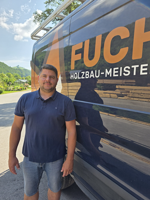 Geschäftsführer Ing. Christoph Fuchs bei Firmenbus stehend